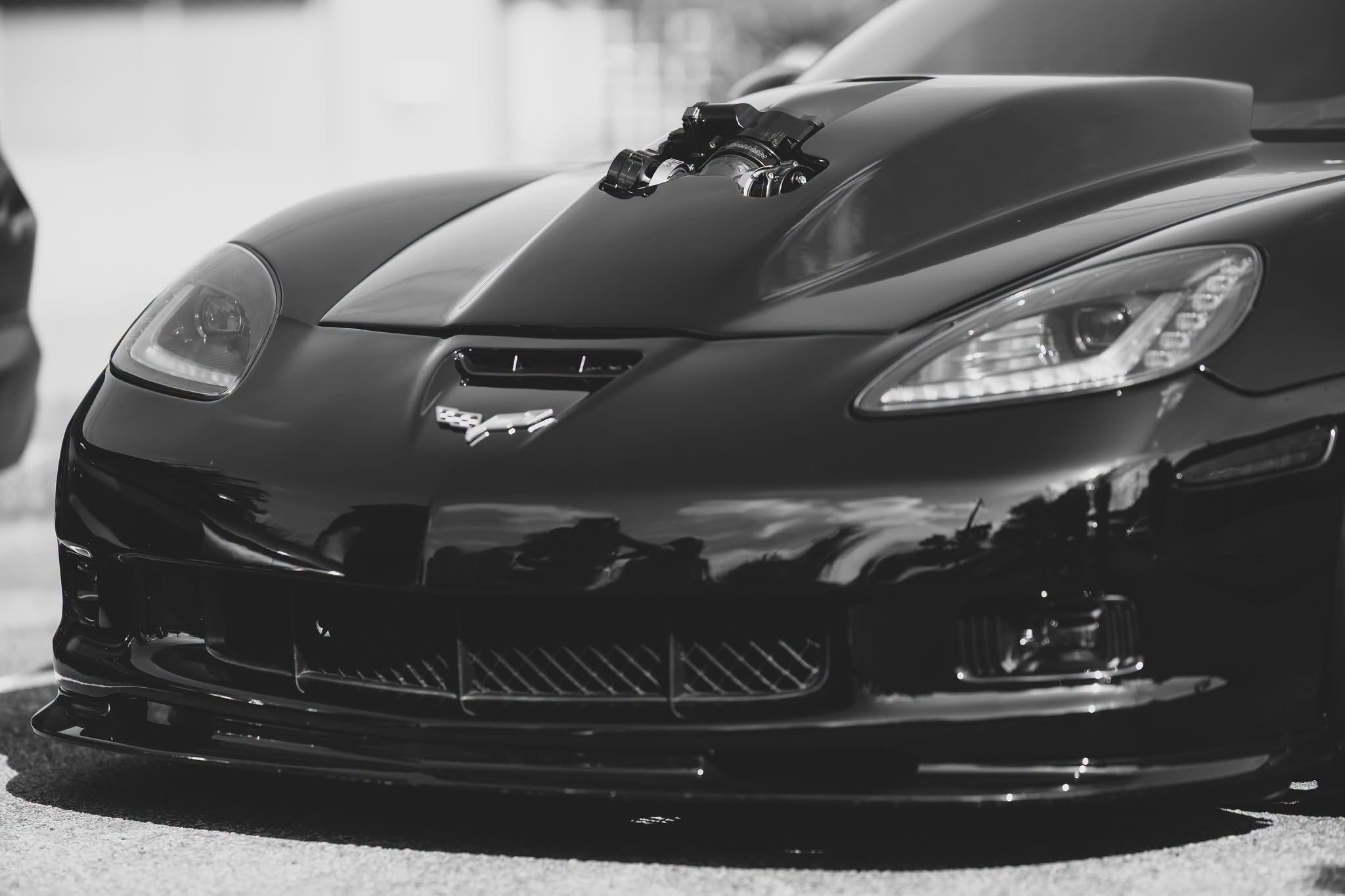 Roger Riddle’s black Corvette with exposed intake hardware above the hood